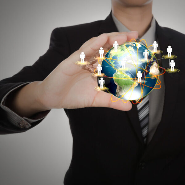 Business man holding the small world in his hands against white